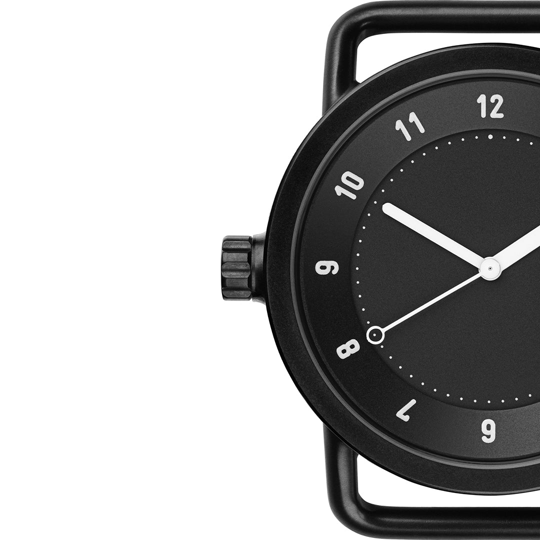 Close-up of TID No.1 black dial watch with 9 o’clock crown and minimalist case design