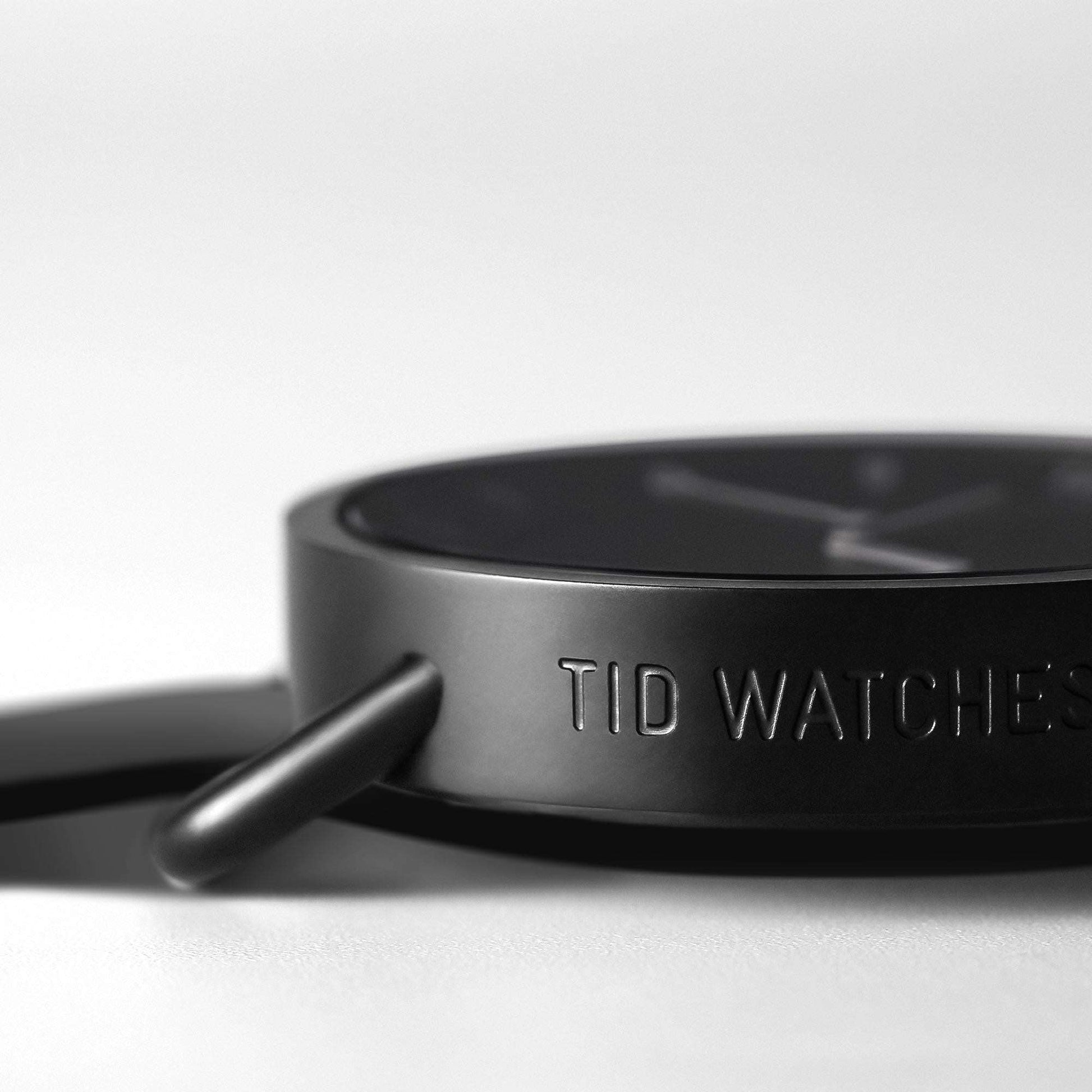 Close-up of TID No.1 black watch case with embossed TID Watches logo and minimalist design