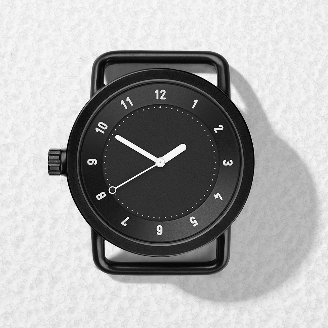 TID No.1 black dial minimalist watch head with 9 o’clock crown on light textured surface