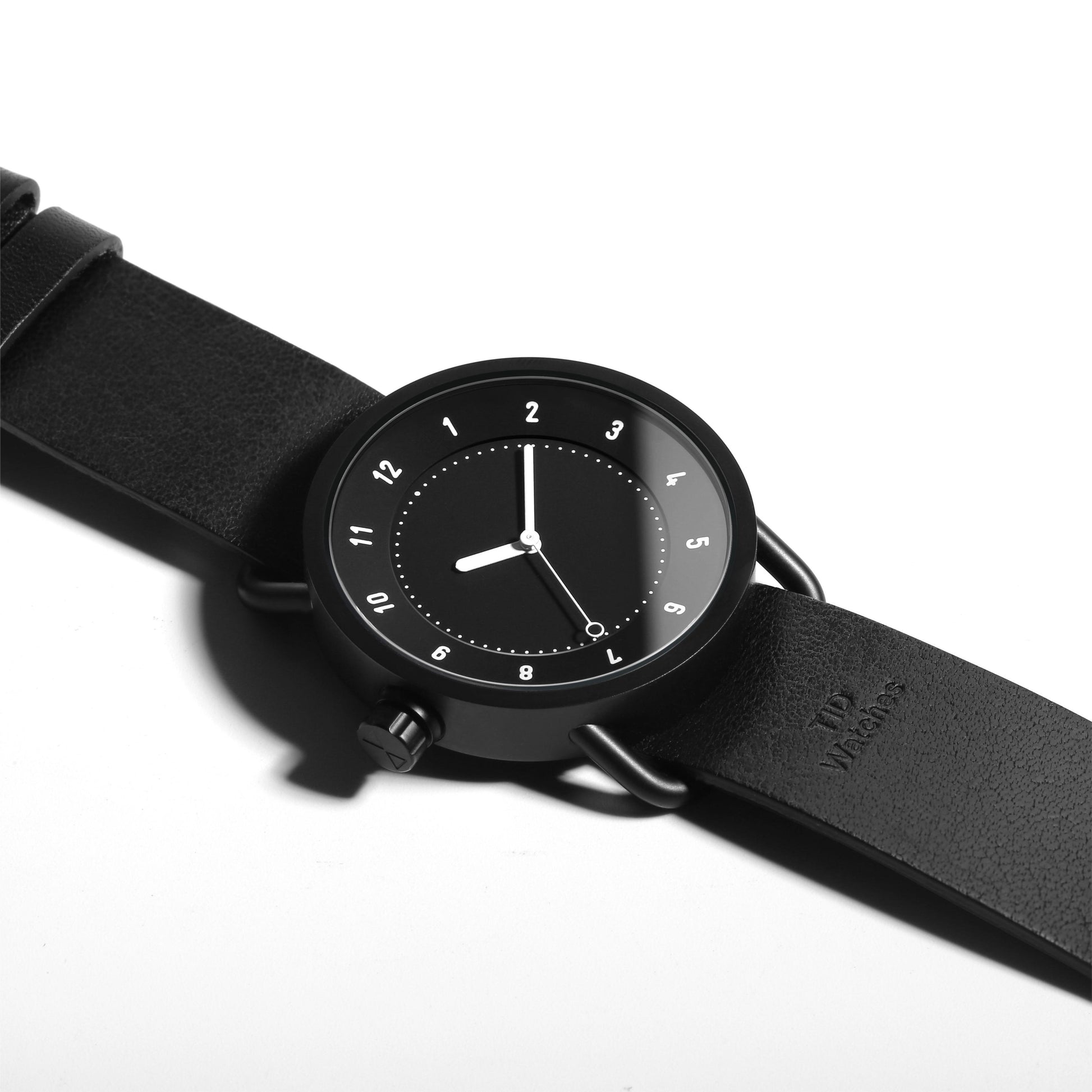 TID No.1 black dial minimalist watch with black leather strap and 9 o’clock crown
