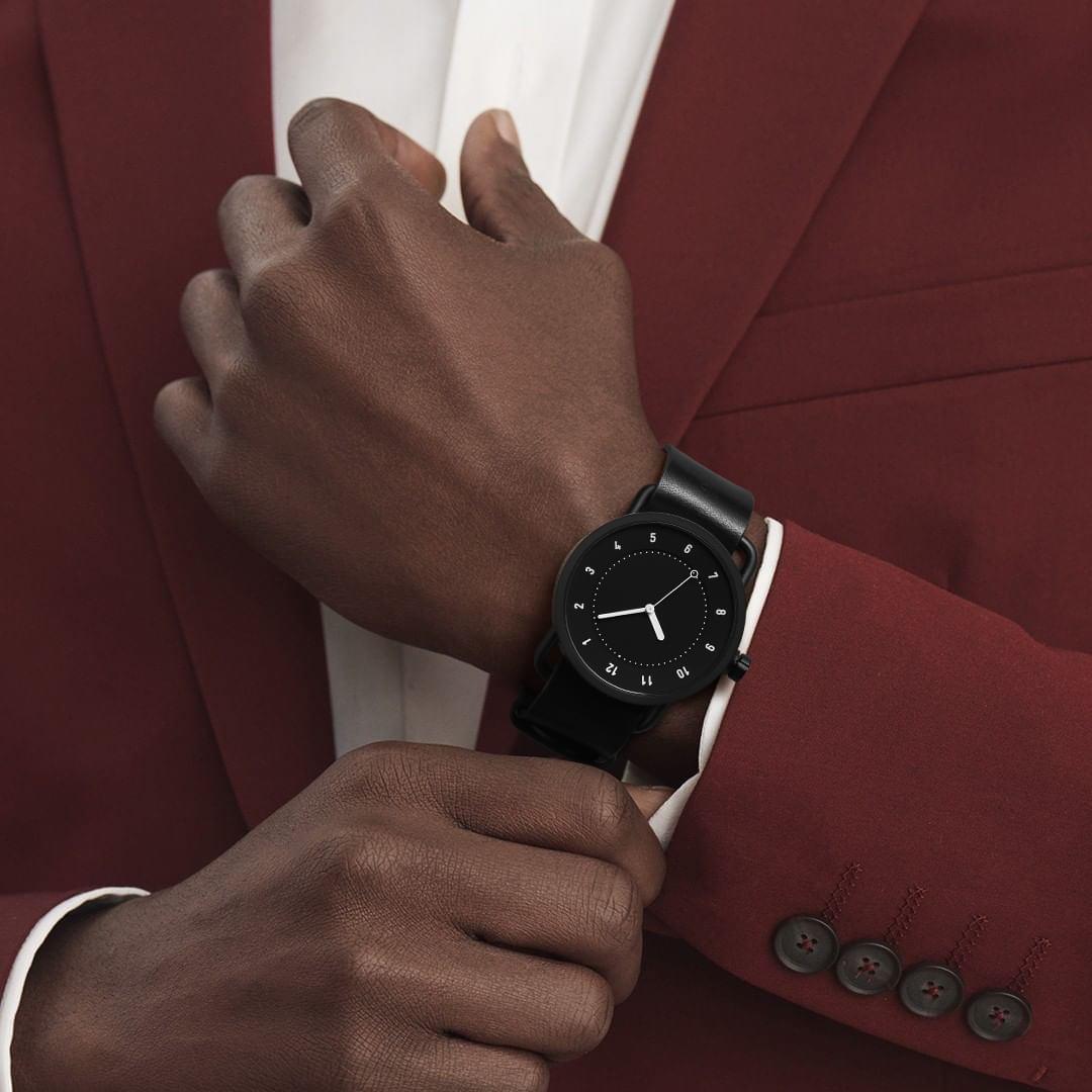 TID No.1 black dial minimalist watch worn with burgundy suit for formal business style