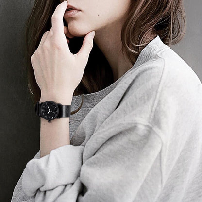 TID No.1 black leather strap watch worn with white sweater for everyday minimalist style