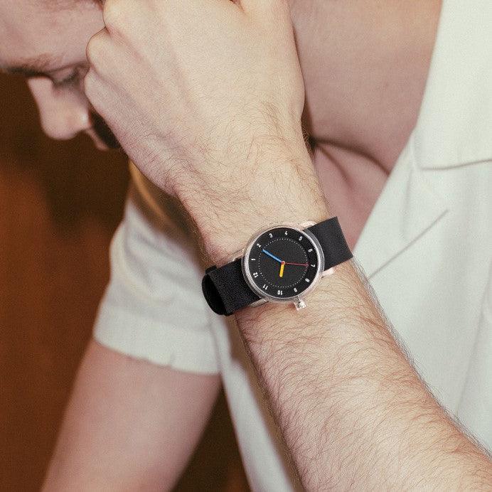 TID No.3 lightweight Swedish watch with black silicone strap, black dial and transparent TR90 case worn with light shirt